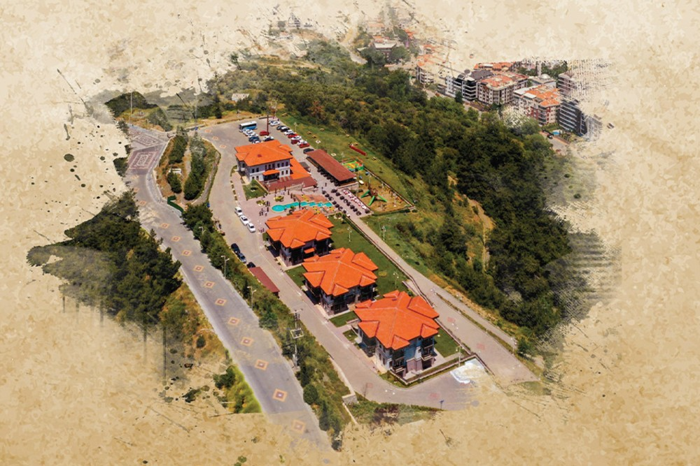 Yeşil bir yamaç üzerine kurulu, turuncu kiremit çatılı binalardan oluşan bir tesisin kuş bakışı görünümü. Tesisin çevresinde ağaçlık alanlar, otopark, çocuk oyun parkı ve yürüyüş yolları bulunuyor. Arka planda ise daha yoğun yerleşimli bir şehir dokusu yer alıyor. Görsel, kenarları eskitilmiş kağıt dokusu efektiyle çerçevelenmiş.